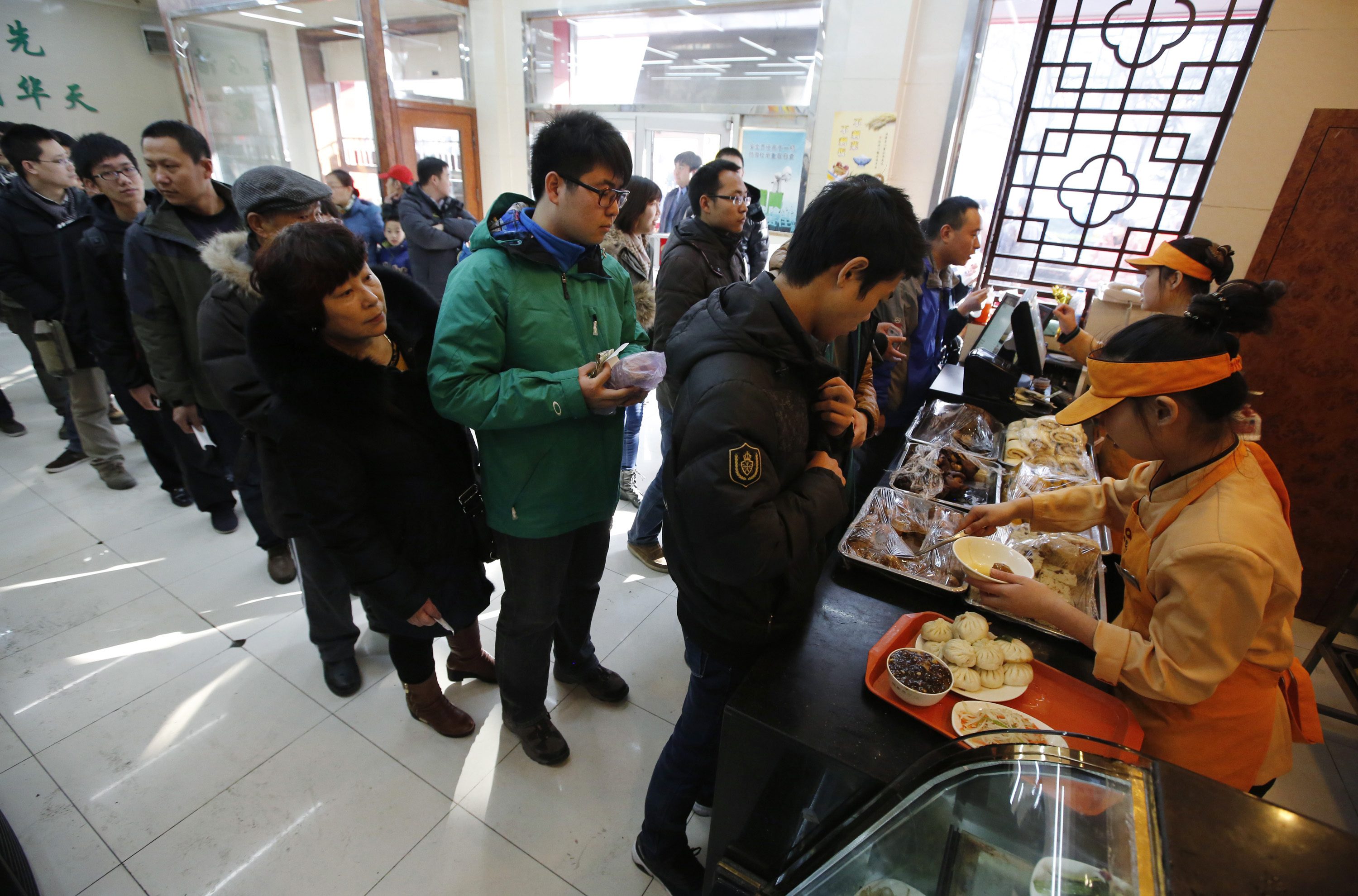 Customers line up to buy steamed buns which Chinese President Xi ate on Saturday, at the Qing-Feng steamed buns restaurant in Beijing